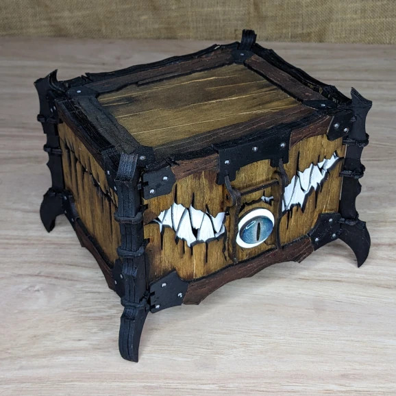 Wooden fantasy treasure chest with mimic design and metal accents, ideal for storing loot or dice.