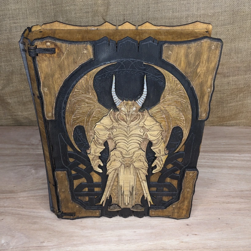 Closed wooden book box with dark fantasy Protector Guardian design engraved on the cover, handcrafted RPG accessory